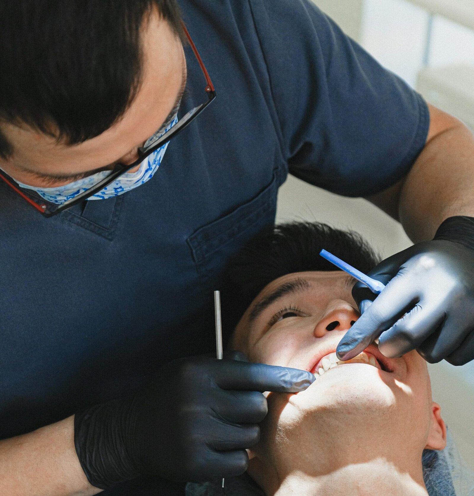 A patient receives dental care from a professional dentist in a clinic setting.