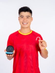 Happy man in red shirt holding a clear dental retainer and its case, showcasing dental care.